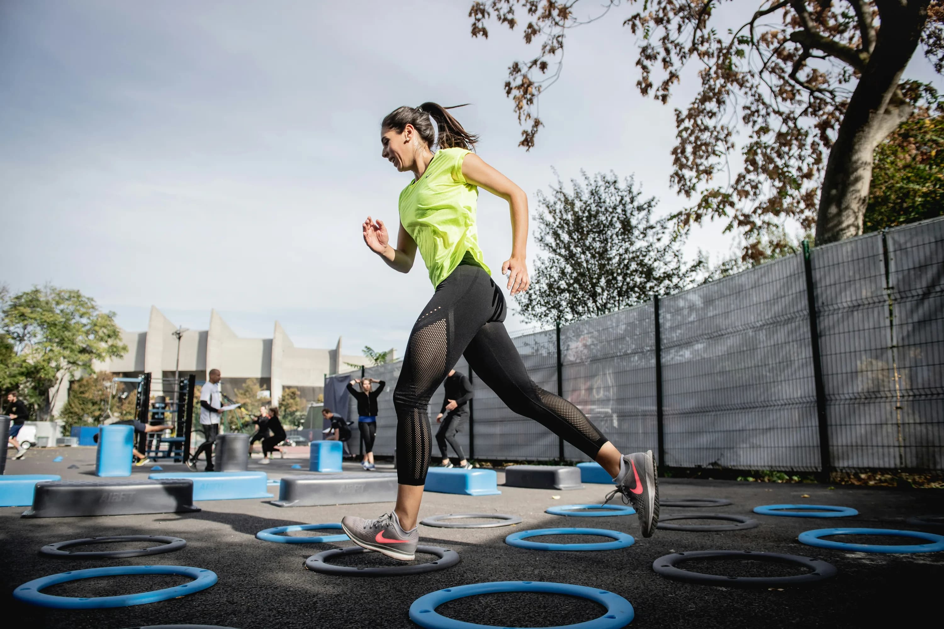 Mujer entrenando al aire libre en una pista de agilidad