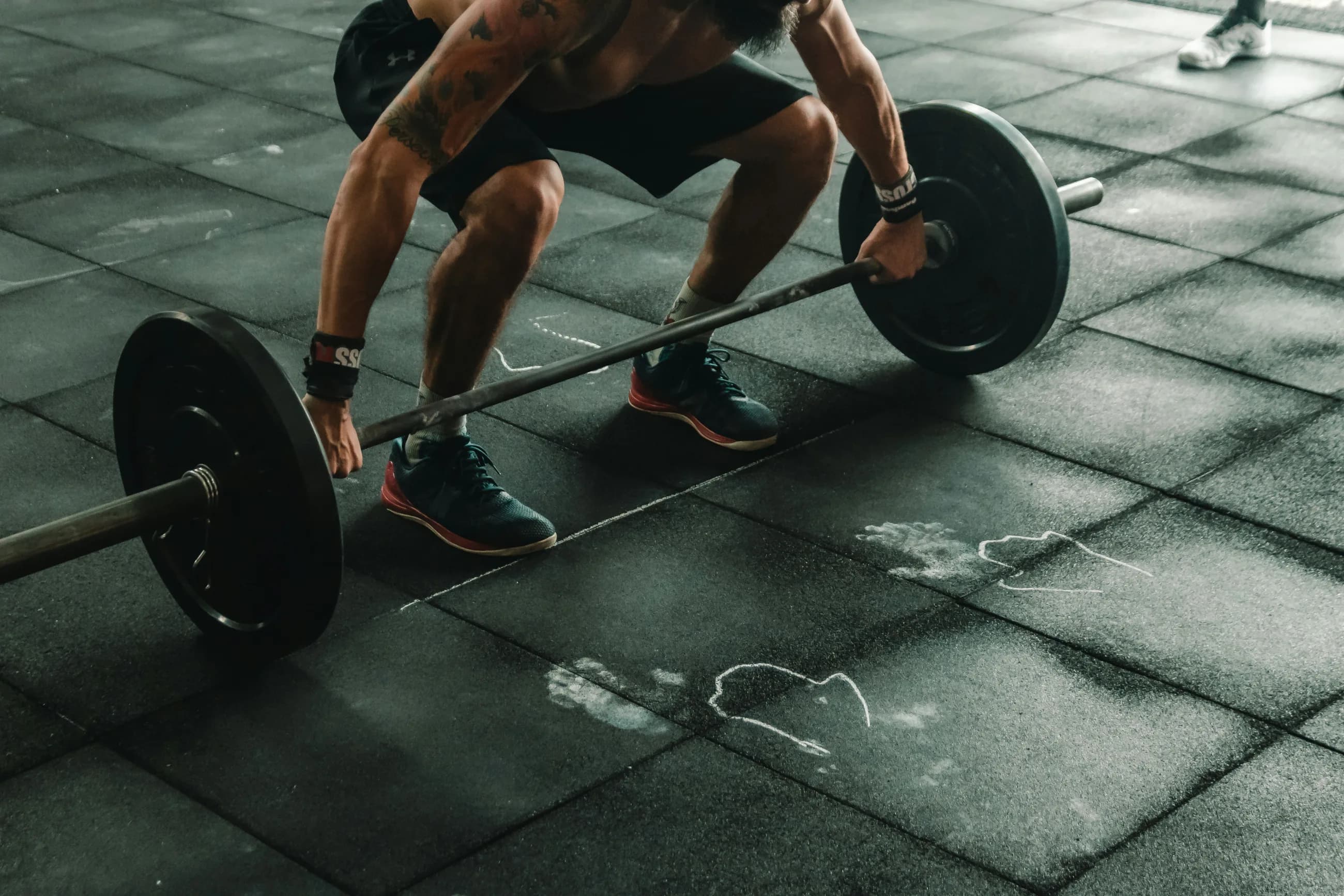 Atleta levantando una barra con pesas en un gimnasio
